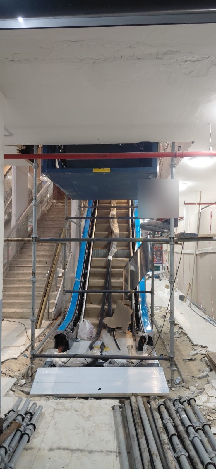 Working platform scaffolding arranged around an escalator installation area