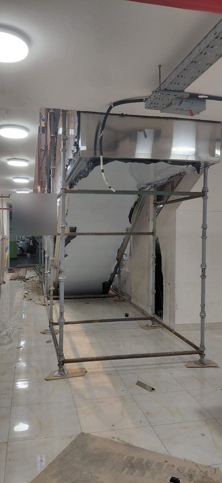 Access scaffolding frame installed beneath an escalator for inspection and repair access