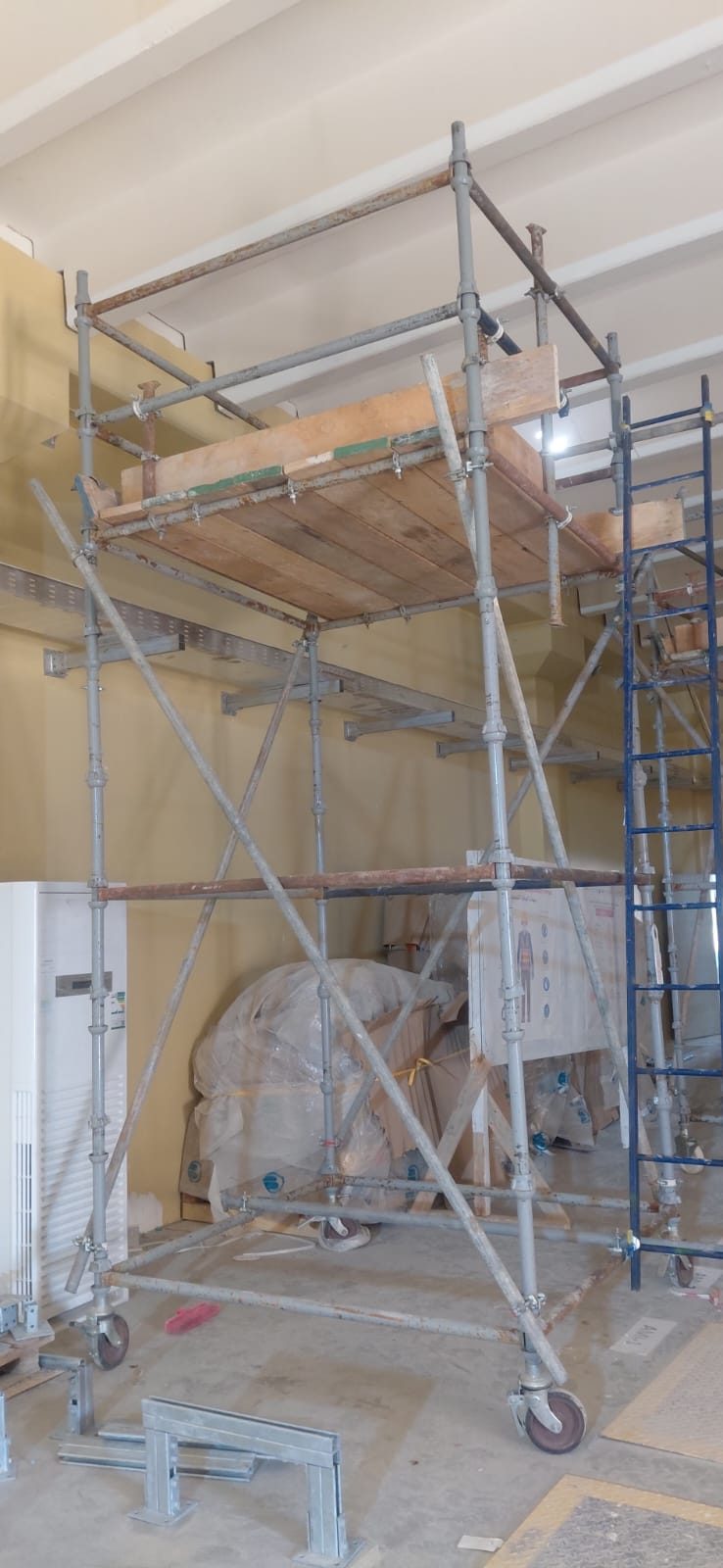Braced mobile access tower positioned for indoor mechanical installation work