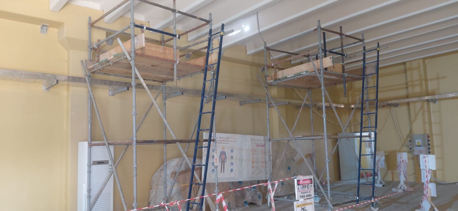 Mobile scaffolding towers erected indoors for overhead equipment installation access