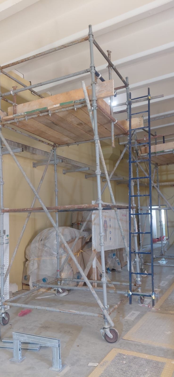 Scaffolding tower with timber decking providing safe access to indoor ceiling services