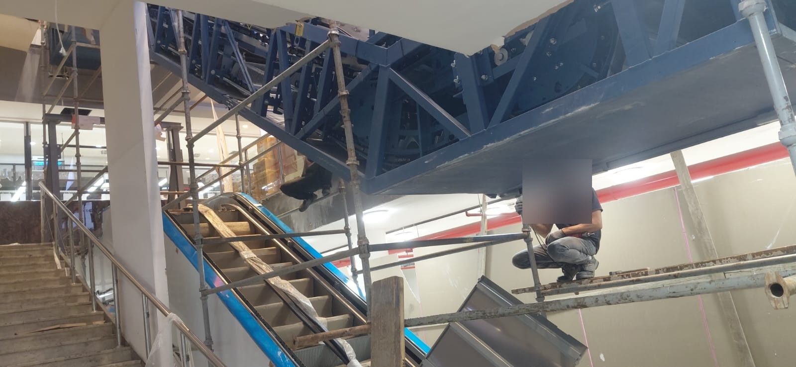 Multi-level scaffolding platform beside an escalator structure for servicing access
